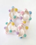 Par de laços com pompons de tulê